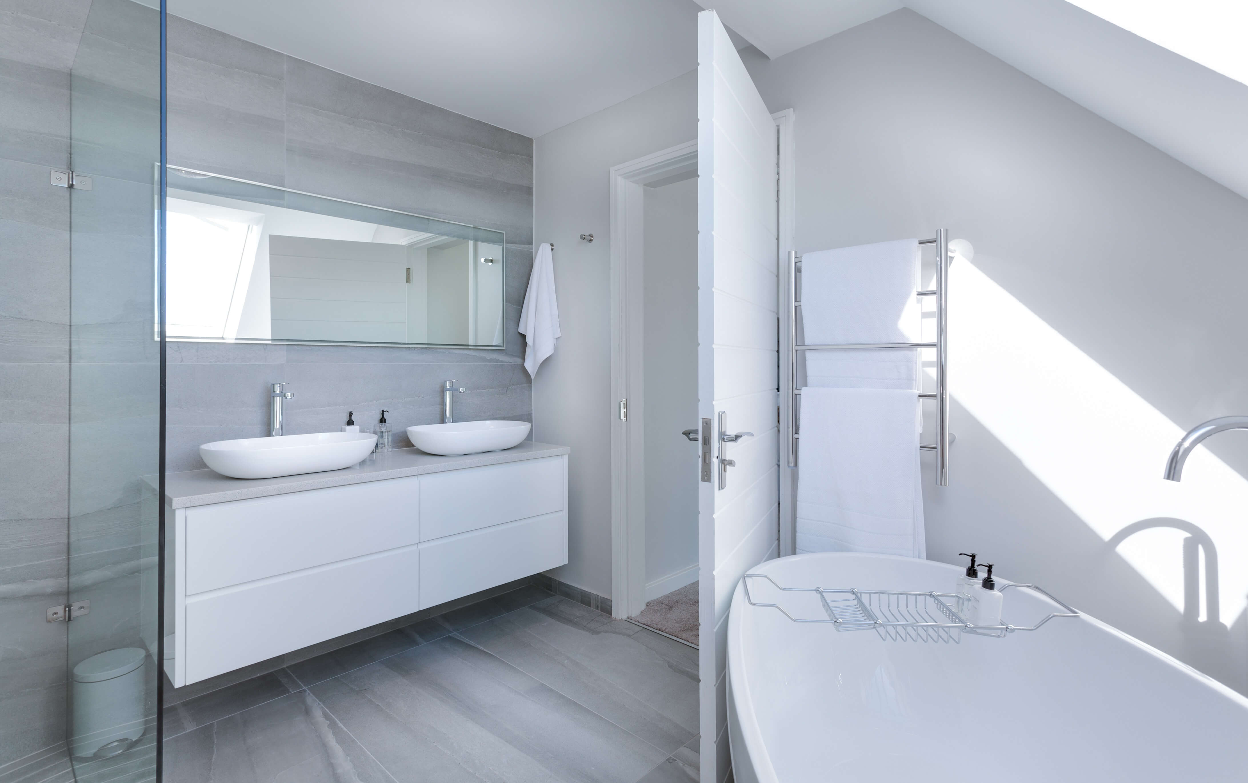 A modern bathroom with clean tub and two sinks