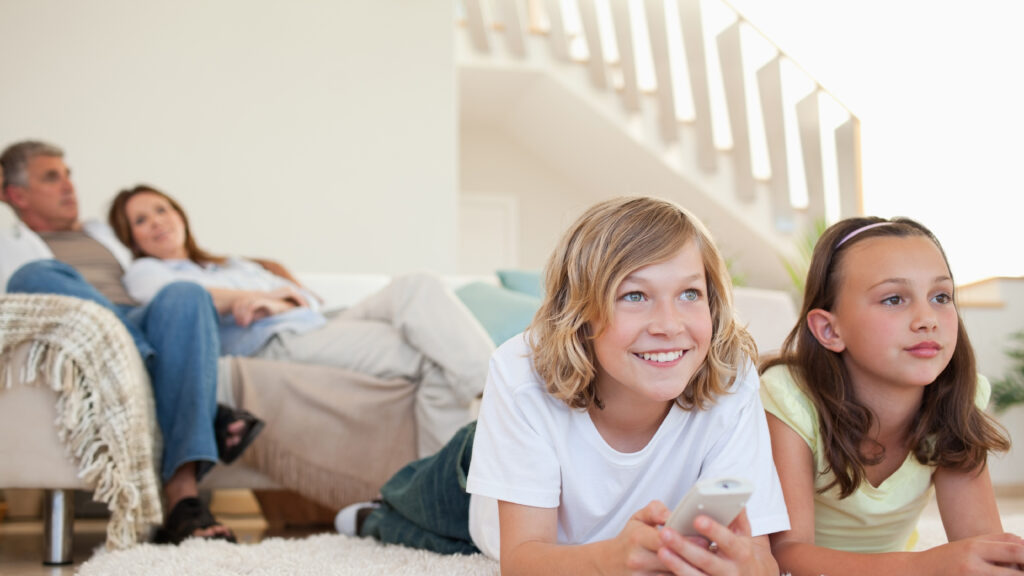 family in living room and kids laying on carpet for family movie night