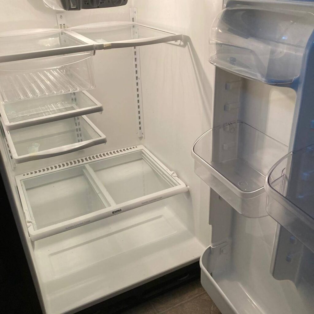 A fully cleaned and organized refrigerator interior with spotless glass shelves and fresh compartments.